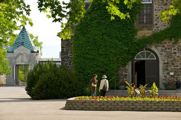 Deux dames en train de marcher vers une porte du Sanctuaire Notre-Dame-du-Cap