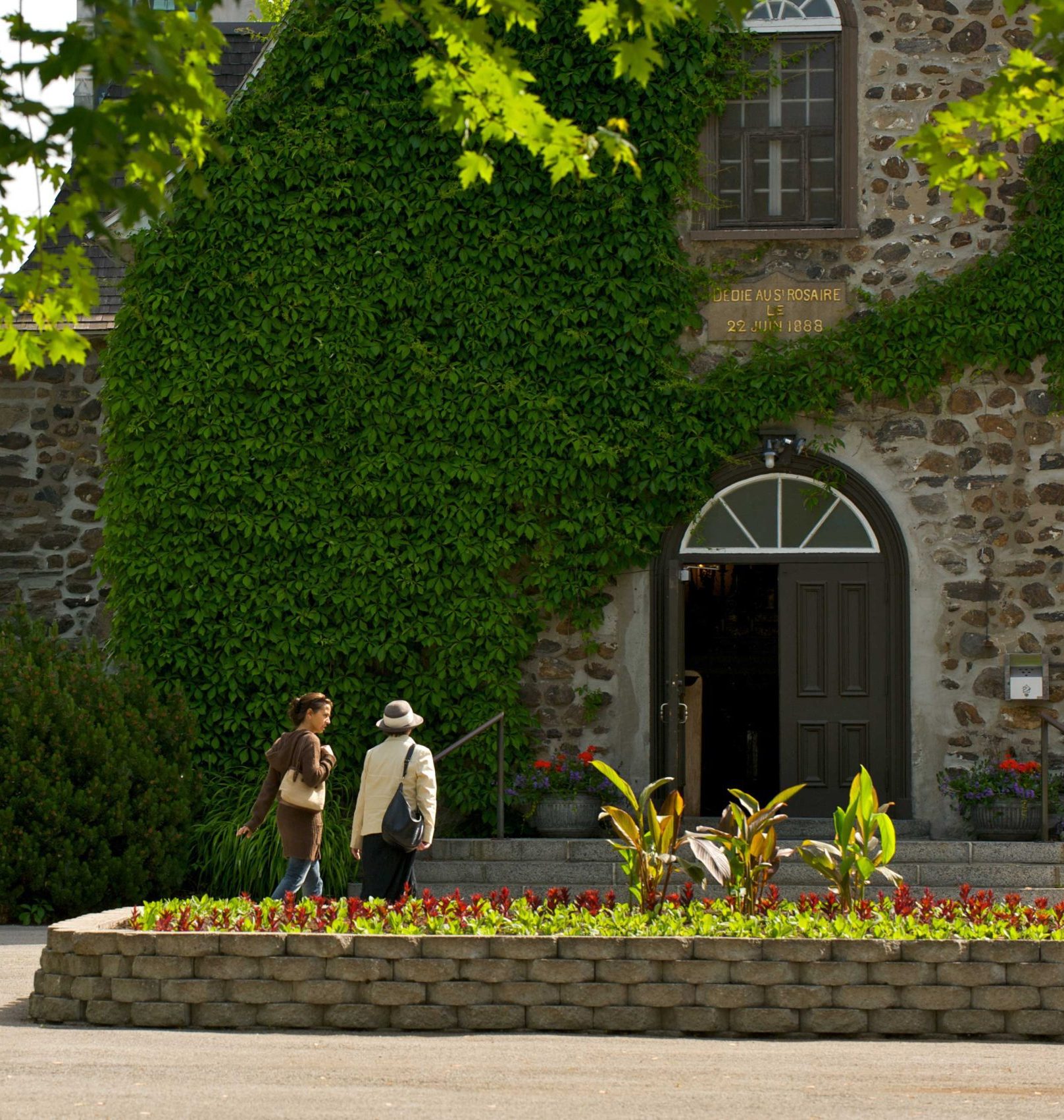 Deux dames en train de marcher vers une porte du Sanctuaire Notre-Dame-du-Cap