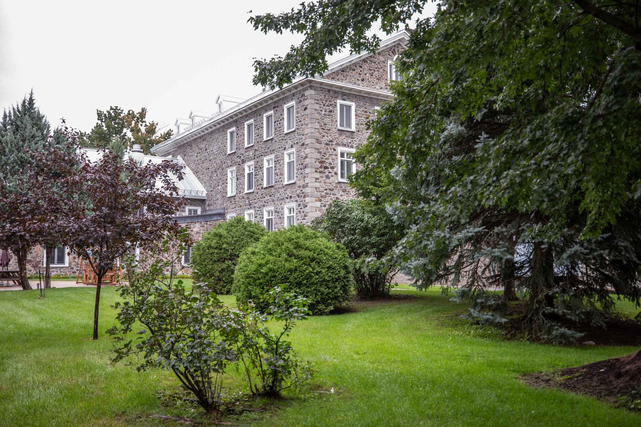Extérieur d'un bâtiment patrimonial entouré de verdure au Centre Marie-Rose, en Montérégie.